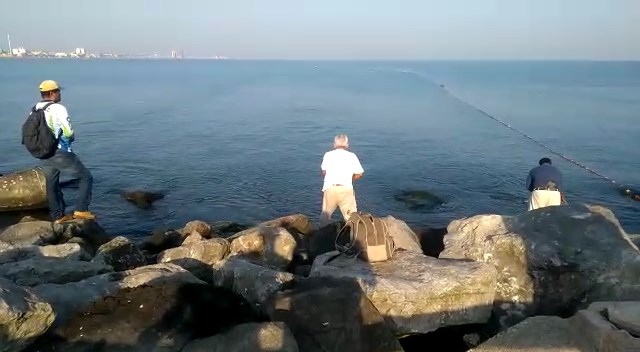 Pescadores de Coatzacoalcos de la vieja escuela en la escollera que separa la bocana del río del mar